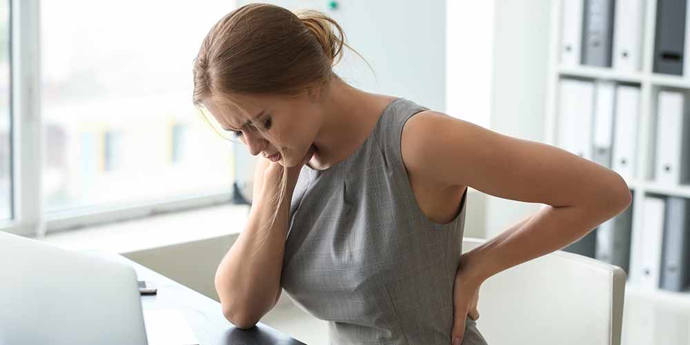 Frau Arbeit Scheibtisch Schmerzen Rücken sitzen Belastung